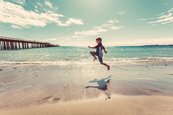 Boy skipping on beach - find tips on using waterproof enhancing technologies in sunscreen formulations in the Prospector Knowledge Center.