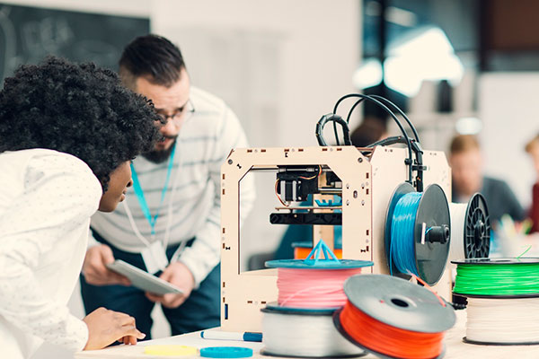 photo of people using a 3D printer - learn more about 3D printing materials