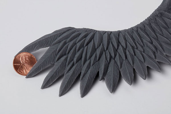 Photo of a bird wing holding a penny - Learn more about Low Force Stereolithography