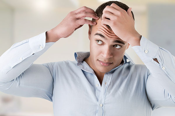 Man looking at hair loss - Learn the facts about hair growth technology