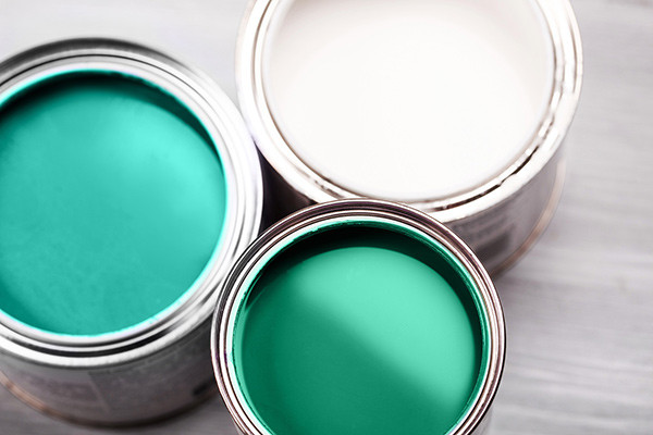 Photo of green and white paint in cans - Learn the difference between wetting agents and dispersants